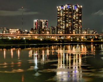 Reflection of illuminated buildings in city at night