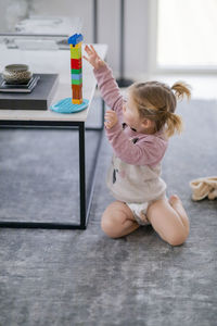 Cute girl sitting on floor at home