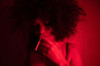 Portrait of woman against red wall