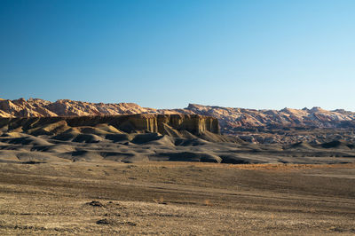 Rock formations in desert against clear blue sky