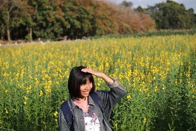 Smiling woman standing against plants