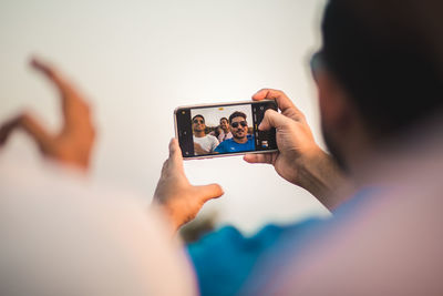 Good looking group of friends using a mobile phone to take a selfie together 