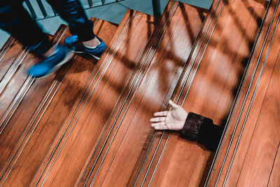 High angle view of person hand and low section on staircase