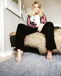 Full length of woman sitting at home