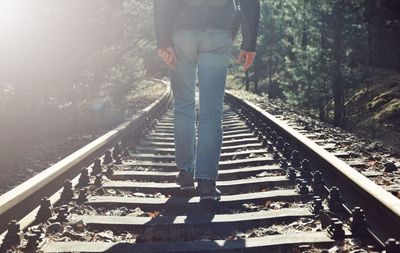 Low section of man standing on railroad track