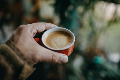 Close-up of hand holding coffee cup