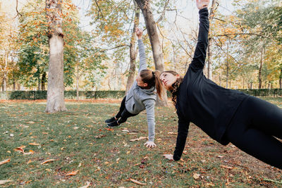 Women exercising at park during autumn