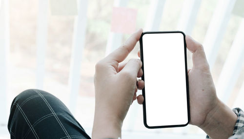 Midsection of man using mobile phone