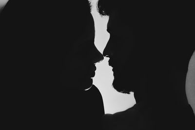 Close-up of silhouette couple romancing