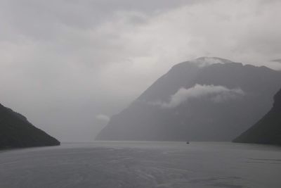 Scenic view of sea and mountains against sky