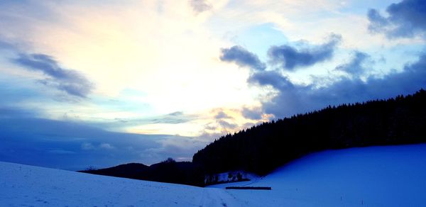 Scenic view of snowcapped mountains against sky during sunset