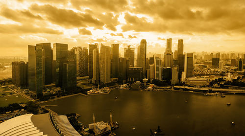 Modern buildings in city against sky during sunset