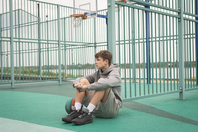 Side view of young man exercising in gym