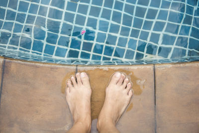 Low section of man legs in swimming pool