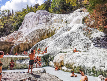 Group of people on rock against waterfall