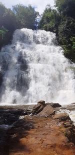 Scenic view of waterfall against sky