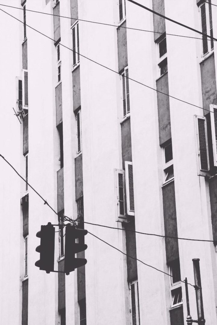 low angle view, architecture, built structure, building exterior, power line, cable, building, day, electricity, window, no people, power supply, outdoors, residential building, sky, city, pole, hanging, residential structure, electricity pylon