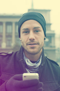 Portrait of man using smart phone in city