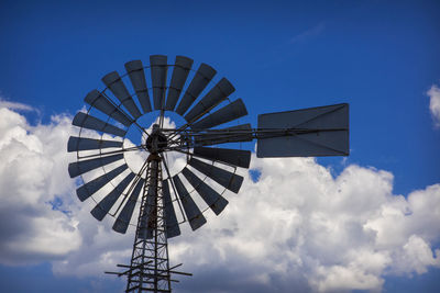 Low angle view of traditional windmill against blue sky