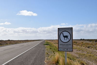 Road signs on landscape against sky