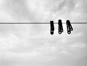 Low angle view of clothespins hanging on clothesline