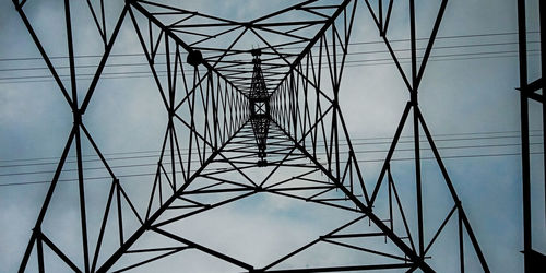 Low angle view of electricity pylon against clear sky