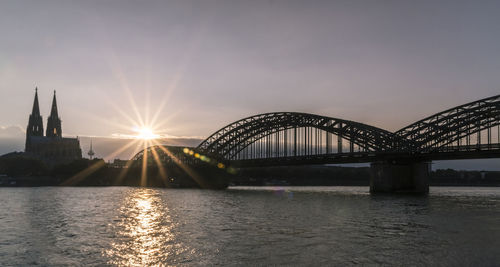 View of bridge over river at sunset