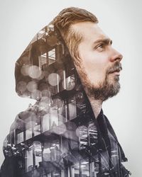 Double exposure on man wearing hooded shirt and buildings against white backgroundd