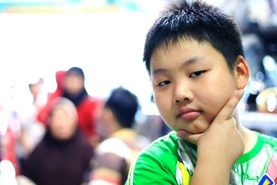 Close-up of cute boy with hand on chin