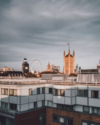 View of buildings in city against cloudy sky