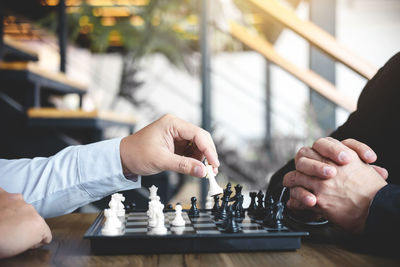 Close-up of business colleagues playing chess in office