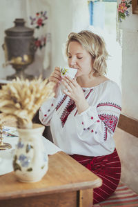 Young woman drinking coffee at home