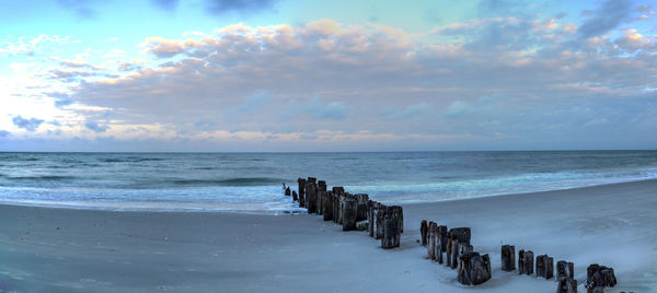 Dawn over a dilapidated pier on the beach in port royal in naples, florida.