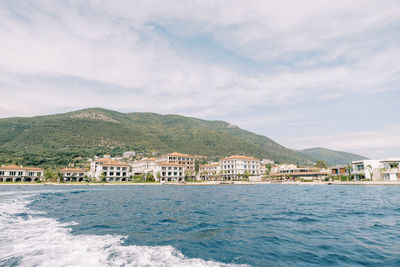 Scenic view of sea by buildings against sky