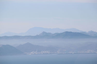 Scenic view of mountains in foggy weather against sky