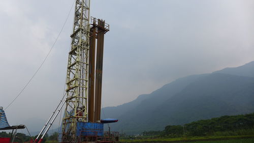 Vintage drilling rig against rice paddy fields and mountains