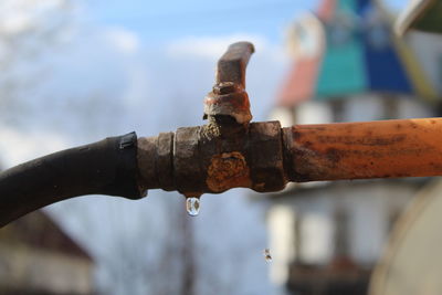 Close-up of water faucet against blurred background