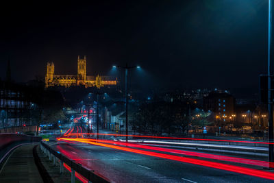 Light trails on road in city at night