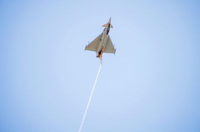 Low angle view of airplane flying against blue sky