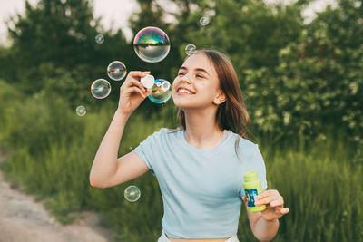 Cute girl making bubble outdoors