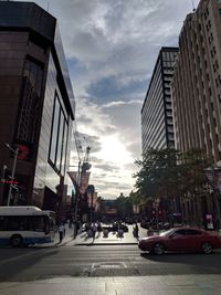 Cars on street in city against sky