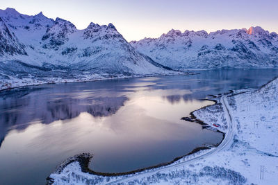 Scenic view of frozen lake and mountains against sky