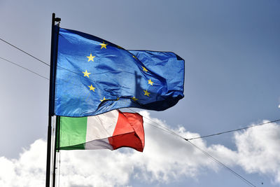 Low angle view of flag against blue sky