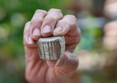 Close-up of human hand holding rusty metal