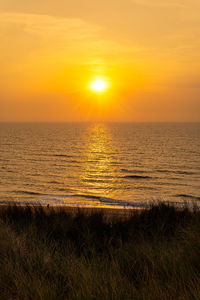 Scenic view of sea against romantic sky at sunset