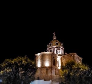 Low angle view of illuminated building against sky at night