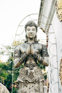 Close-up of angel statue against building