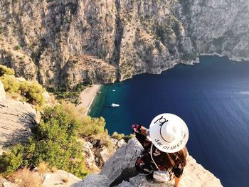 High angle view of woman wearing hat on cliff over sea