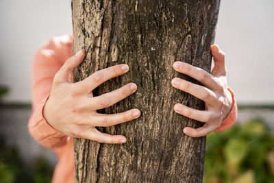 Woman embracing tree trunk in garden