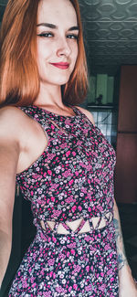 Portrait of young woman standing against wall